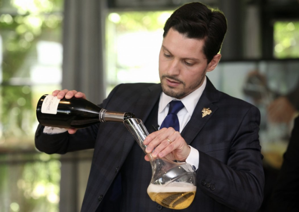 A discreet Prémices sommelier pouring for a private Paris dinner
