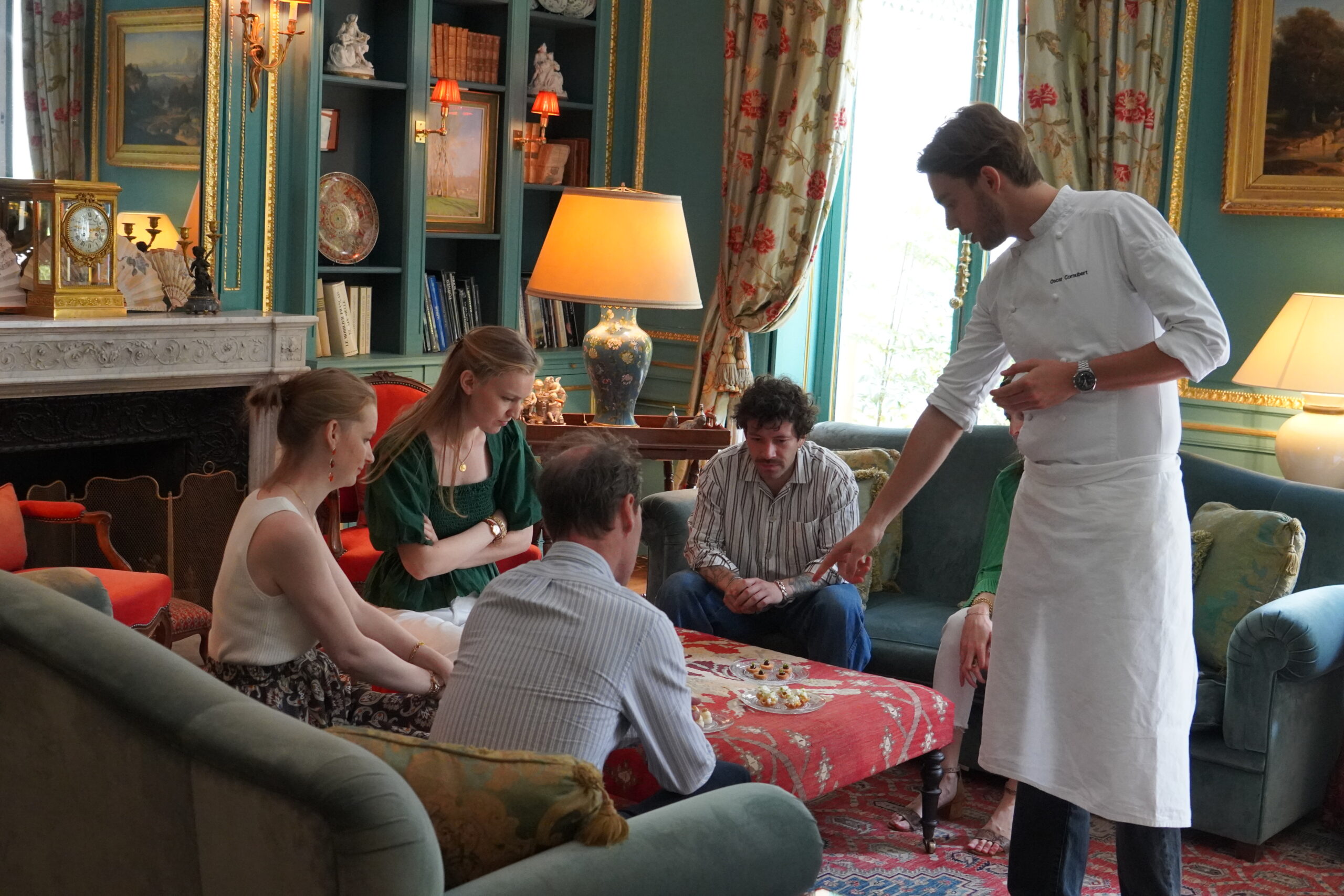 A Prémices private chef composing a bespoke dinner for guests in a Paris salon